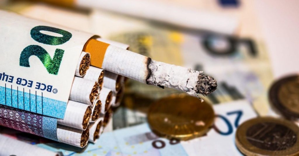 A tobacco cigarette & money